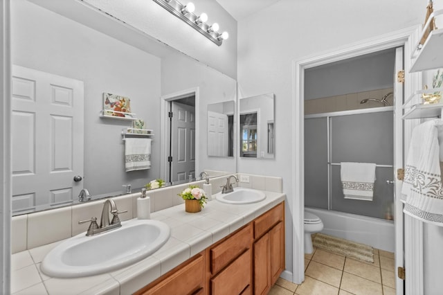 993 Pinewood Ave, Sanger, CA 93657 - bathroom with toilet, tile patterned floors, double vanity, and combined bath / shower with glass door