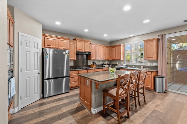993 Pinewood Ave, Sanger, CA 93657 - kitchen featuring appliances with stainless steel finishes, a kitchen island, light wood-type flooring, a breakfast bar, and recessed lighting