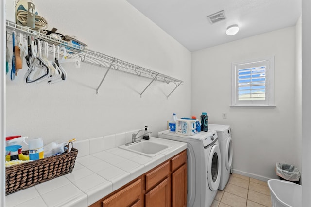 993 Pinewood Ave, Sanger, CA 93657 - washroom featuring cabinet space, washer and dryer, light tile patterned floors, and baseboards
