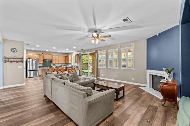 993 Pinewood Ave, Sanger, CA 93657 - living area featuring baseboards, light wood-style floors, a ceiling fan, recessed lighting, and a glass covered fireplace