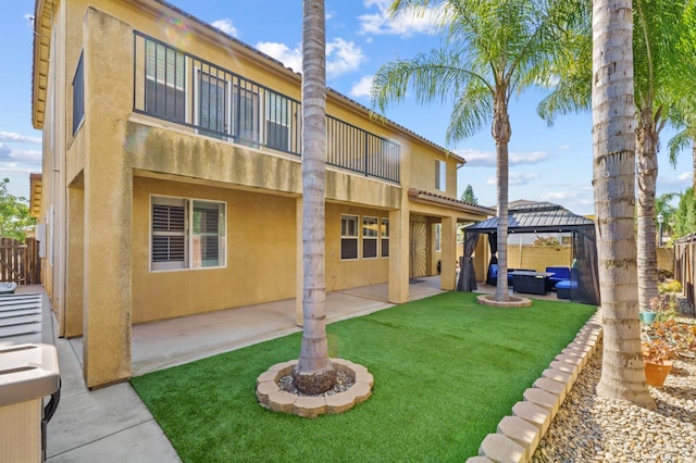 993 Pinewood Ave, Sanger, CA 93657 - rear view of property with a patio, an outdoor hangout area, a gazebo, and stucco siding