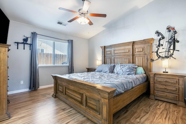 bedroom featuring lofted ceiling, wood finished floors, baseboards, and a ceiling fan