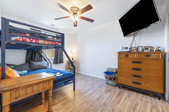 bedroom with light wood finished floors, baseboards, and ceiling fan