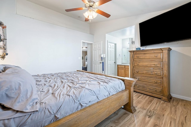 bedroom with vaulted ceiling, light wood-style floors, baseboards, a ceiling fan, and connected bathroom