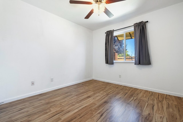 empty room with wood finished floors, ceiling fan, and baseboards