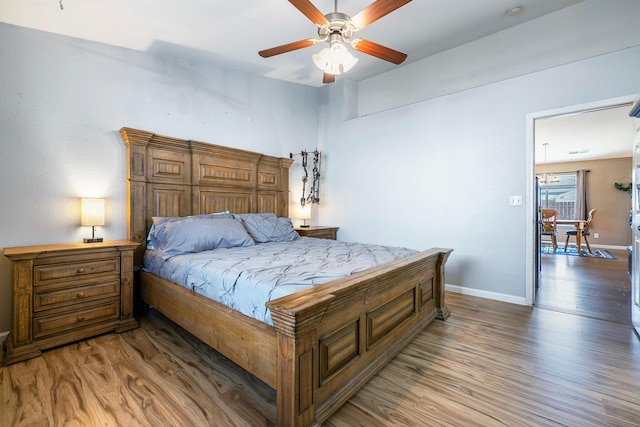 bedroom featuring wood finished floors, baseboards, and a ceiling fan