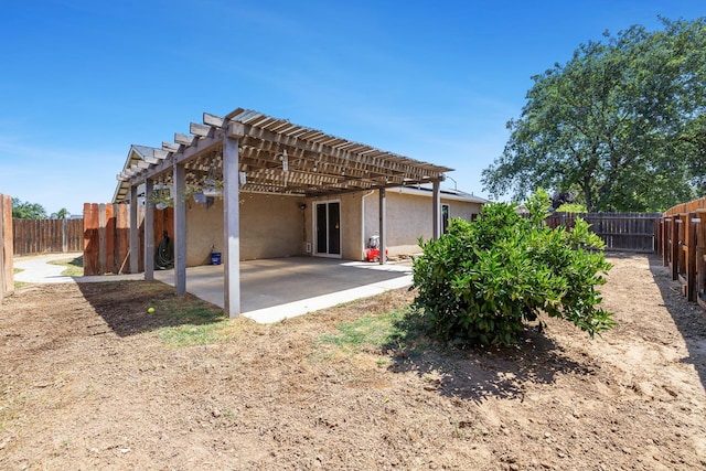back of house featuring stucco siding, a pergola, a patio, and a fenced backyard