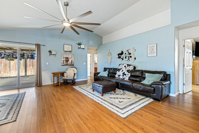 living room with a ceiling fan, healthy amount of natural light, wood finished floors, high vaulted ceiling, and baseboards
