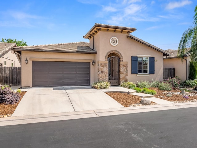 11340 N Via Milano Way, Fresno, CA 93730 - mediterranean / spanish-style home with concrete driveway, an attached garage, stucco siding, and a tiled roof