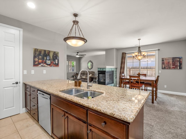 11340 N Via Milano Way, Fresno, CA 93730 - kitchen with a sink, stainless steel dishwasher, a multi sided fireplace, decorative light fixtures, and light stone countertops