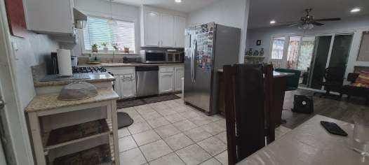 kitchen with appliances with stainless steel finishes, healthy amount of natural light, ceiling fan, white cabinetry, and recessed lighting