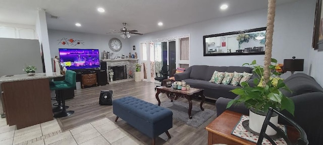 living area with ceiling fan, recessed lighting, light wood-style floors, and a fireplace