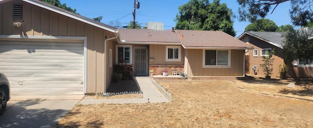 back of house with an attached garage and brick siding
