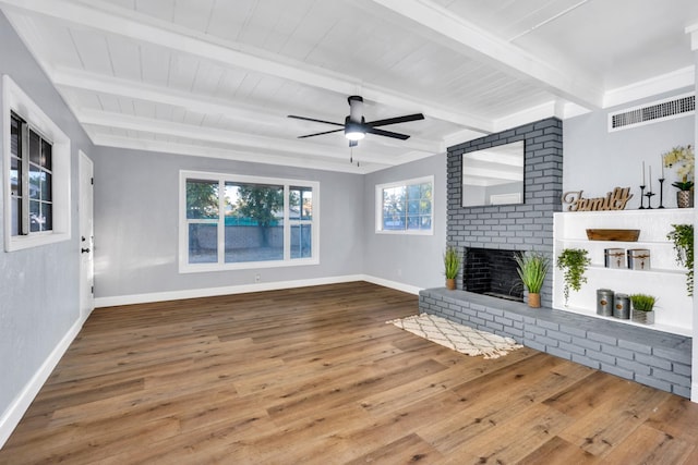 4918 E Illinois Ave, Fresno, CA 93727 - unfurnished living room featuring baseboards, wood finished floors, a ceiling fan, a brick fireplace, and wood ceiling with exposed beams