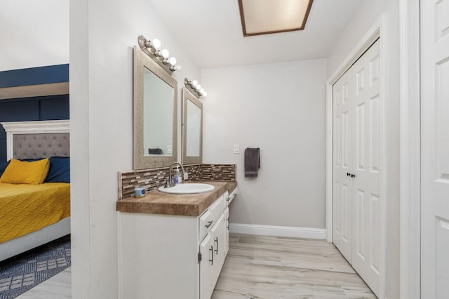 6608 N Haslam Ave, Fresno, CA 93711 - bathroom featuring ensuite bath, vanity, baseboards, decorative backsplash, and wood finished floors