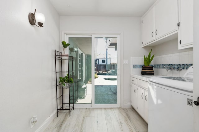 6608 N Haslam Ave, Fresno, CA 93711 - kitchen with washer / dryer, white cabinets, and backsplash