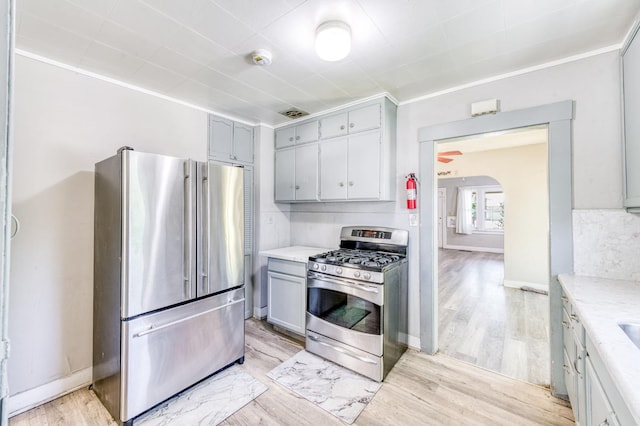 1934 N Vagedes Ave, Fresno, CA 93705 - kitchen with stainless steel appliances, light countertops, light wood-style flooring, gray cabinets, and ornamental molding