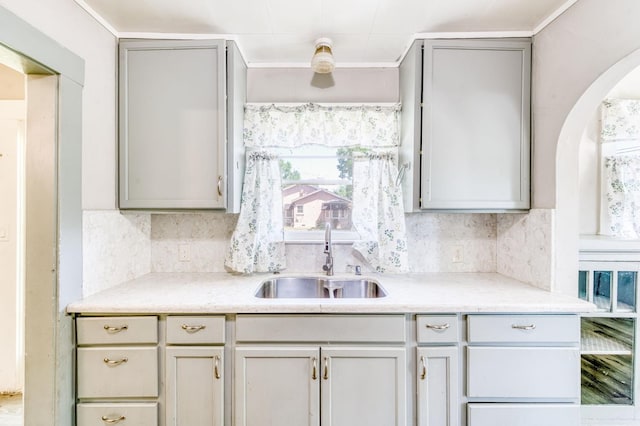 1934 N Vagedes Ave, Fresno, CA 93705 - kitchen featuring a sink, arched walkways, backsplash, and light countertops