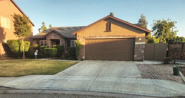 5788 E Mono St, Fresno, CA 93727 - single story home with a garage, driveway, a front yard, a gate, and stucco siding
