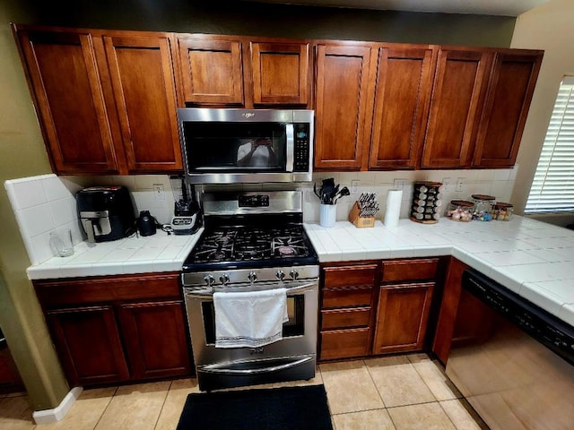 5788 E Mono St, Fresno, CA 93727 - kitchen featuring stainless steel appliances, light tile patterned floors, tasteful backsplash, and tile countertops