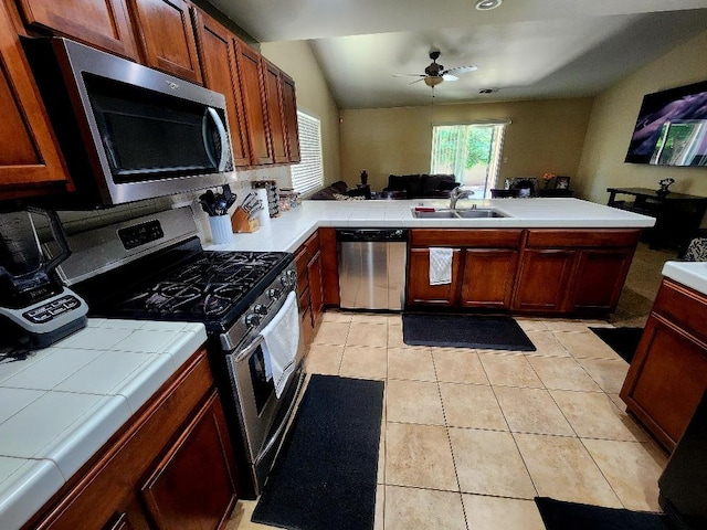 5788 E Mono St, Fresno, CA 93727 - kitchen with appliances with stainless steel finishes, a sink, tile counters, a ceiling fan, and a peninsula