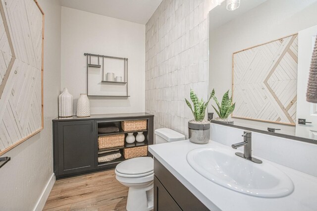 1165 Maclure Ave W, Madera, CA 93636 - bathroom with toilet, tile walls, wood finished floors, vanity, and baseboards