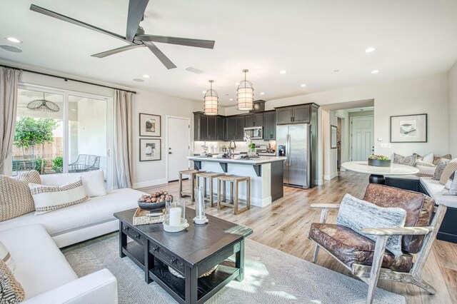 1165 Maclure Ave W, Madera, CA 93636 - living room featuring a ceiling fan, recessed lighting, baseboards, and light wood-type flooring