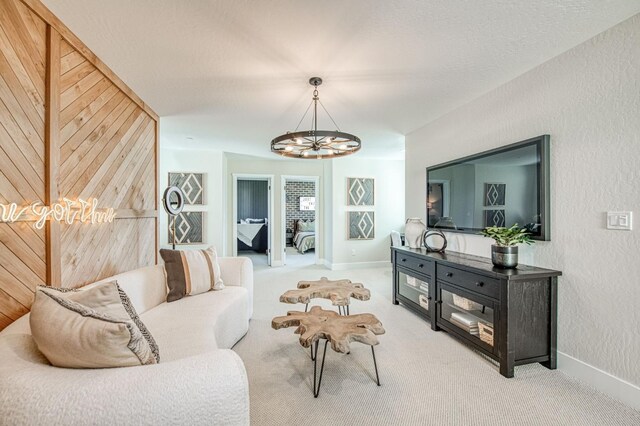 1165 Maclure Ave W, Madera, CA 93636 - living room with a chandelier, carpet flooring, baseboards, and a textured wall