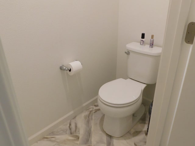 865 S Bridle Ave, Fresno, CA 93727 - bathroom featuring toilet, baseboards, and marble look tiles