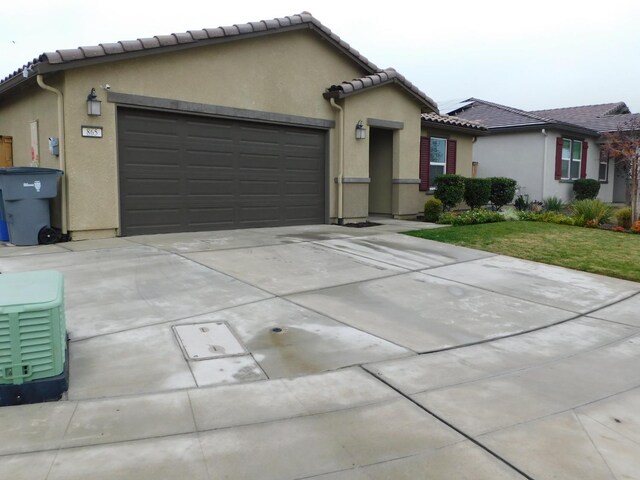 865 S Bridle Ave, Fresno, CA 93727 - view of front of house with an attached garage, driveway, and stucco siding