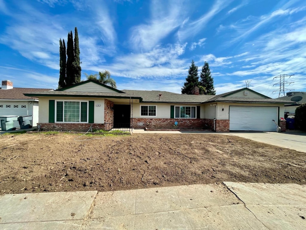 4382 N Crystal Ave, Fresno, CA 93705 - ranch-style home with brick siding, an attached garage, and concrete driveway