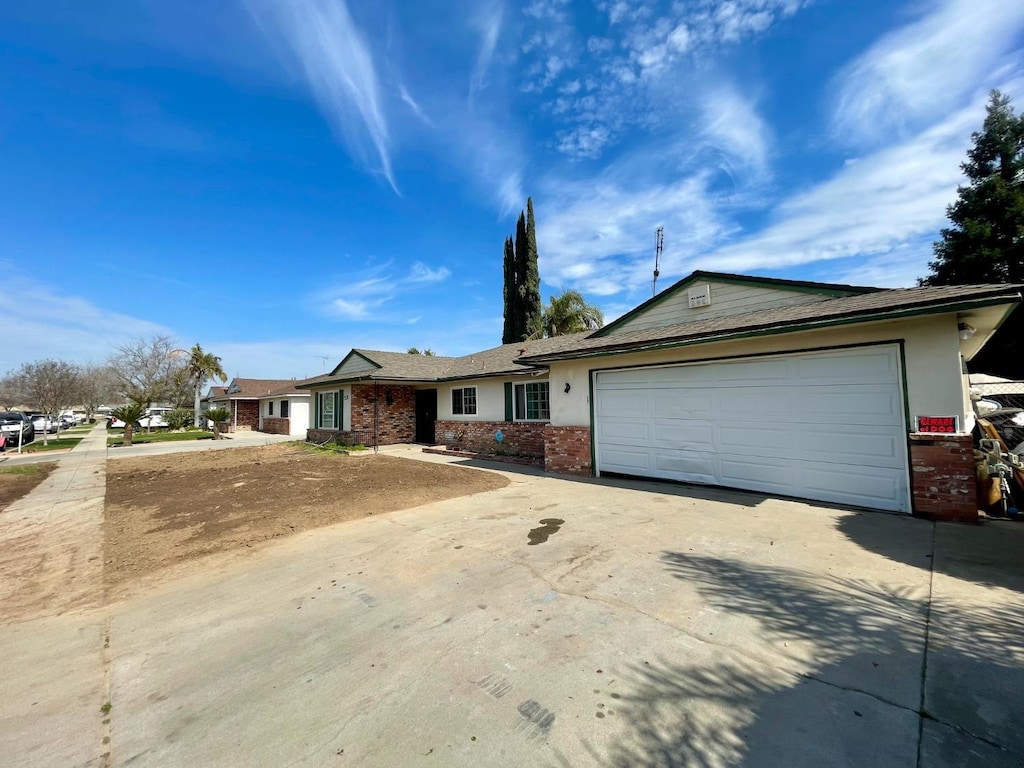 4382 N Crystal Ave, Fresno, CA 93705 - single story home featuring concrete driveway, brick siding, a garage, and stucco siding