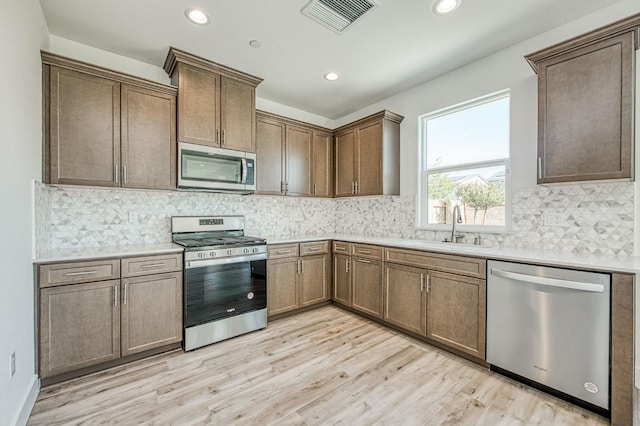1175 Maclure Ave W, Madera, CA 93636 - kitchen featuring appliances with stainless steel finishes, a sink, light wood-style flooring, light countertops, and recessed lighting