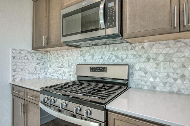 1175 Maclure Ave W, Madera, CA 93636 - kitchen with appliances with stainless steel finishes, light countertops, backsplash, and a textured wall