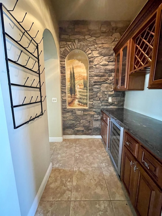 16052 W Middleton Ave, Kerman, CA 93630 - kitchen featuring wine cooler, glass insert cabinets, dark stone countertops, and baseboards