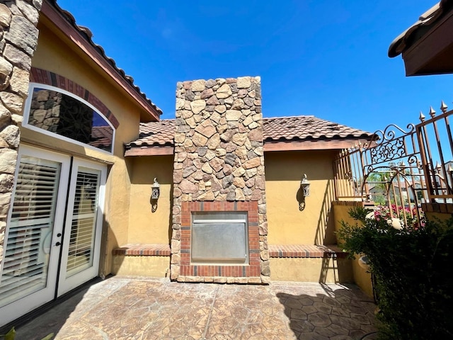 16052 W Middleton Ave, Kerman, CA 93630 - property entrance featuring a tile roof, stucco siding, and a patio