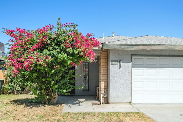 2063 S Tupman Ave, Fresno, CA 93706 - view of front facade featuring stucco siding, a garage, and roof with shingles