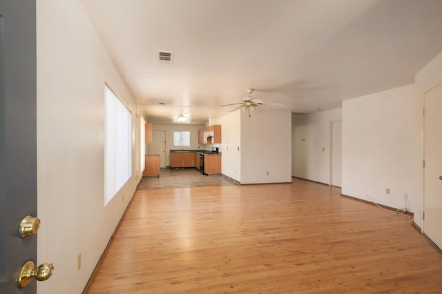 2063 S Tupman Ave, Fresno, CA 93706 - unfurnished living room featuring ceiling fan, light wood-type flooring, and baseboards