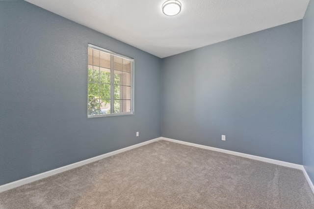 carpeted spare room with baseboards
