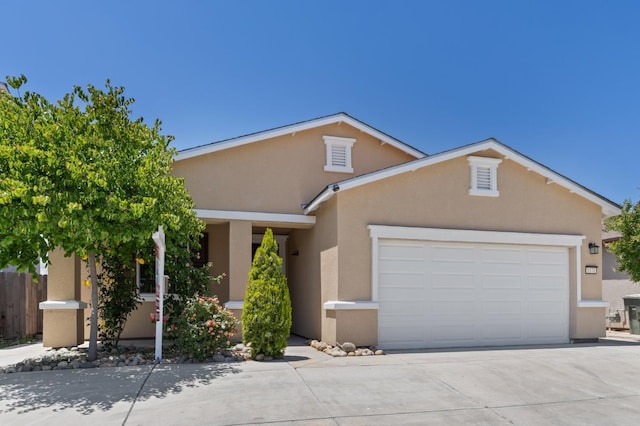 view of front of home featuring stucco siding, concrete driveway, and a garage