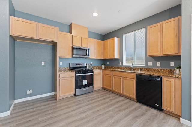 kitchen with stainless steel appliances, light brown cabinets, dark stone counters, and recessed lighting
