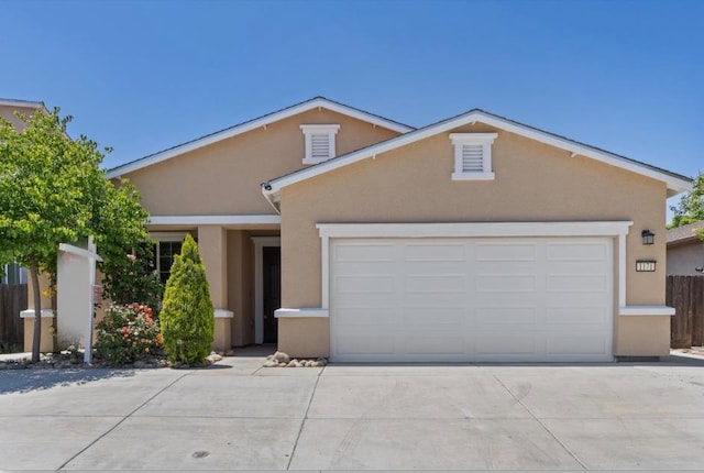 view of front of house with stucco siding, driveway, and a garage