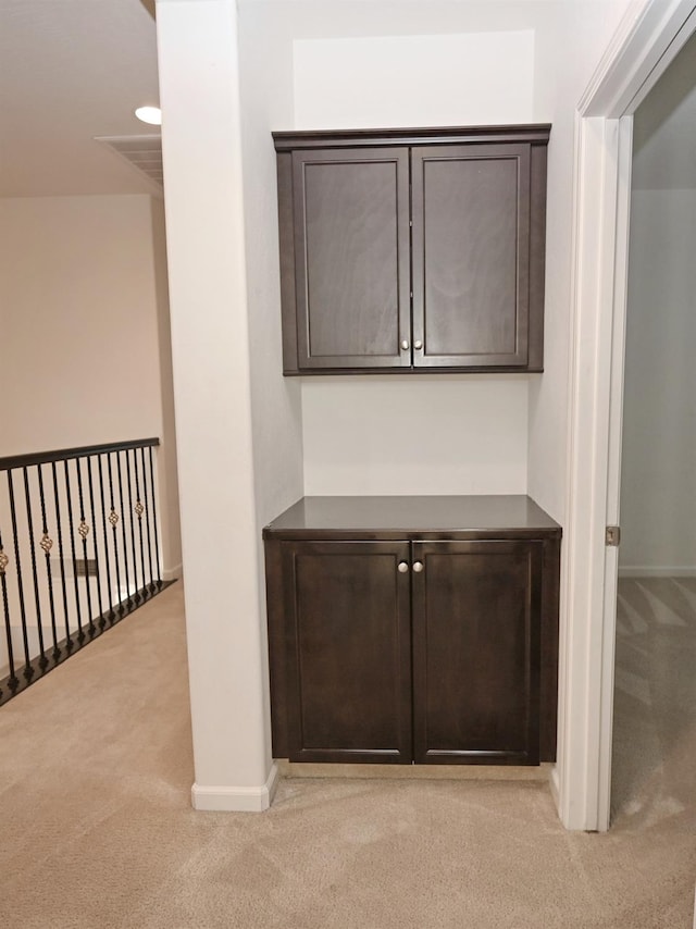 corridor featuring light colored carpet and baseboards