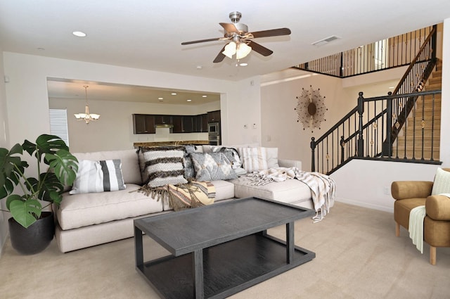 living area featuring light colored carpet, ceiling fan, a chandelier, stairway, and recessed lighting