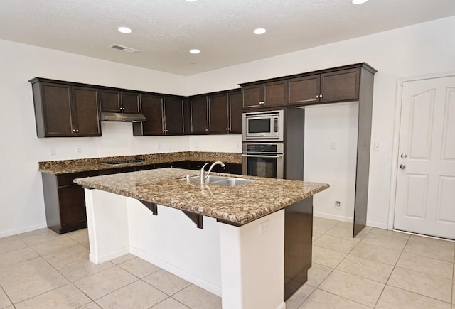 kitchen with appliances with stainless steel finishes, a sink, under cabinet range hood, light tile patterned floors, and recessed lighting