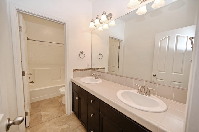 bathroom featuring toilet, double vanity, and bathing tub / shower combination
