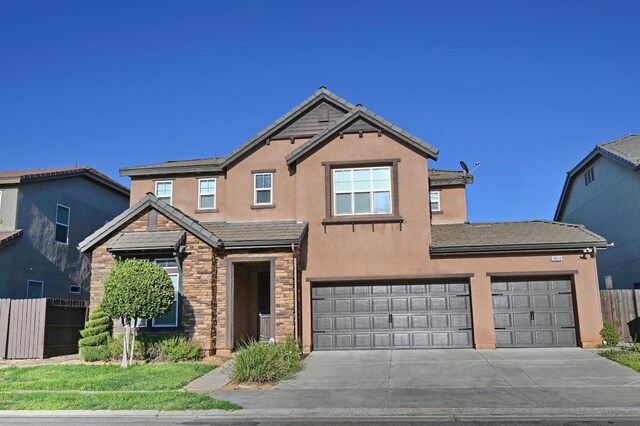 traditional-style home with concrete driveway, stucco siding, a tile roof, stone siding, and a garage