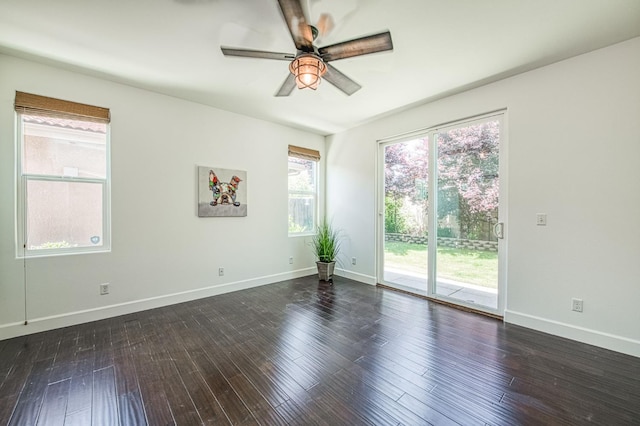 empty room with a ceiling fan, baseboards, and dark wood-style floors