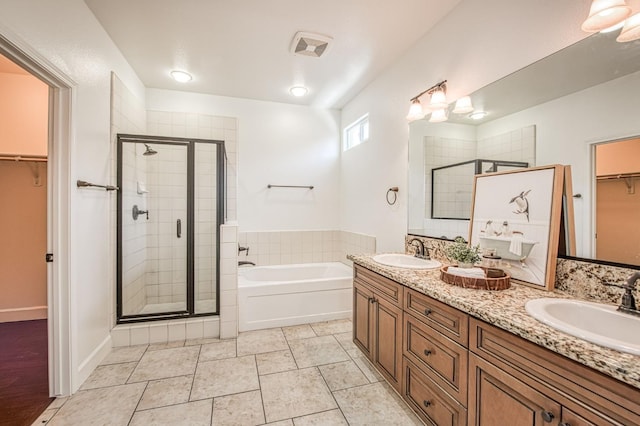 full bath with a shower stall, a garden tub, a spacious closet, and double vanity