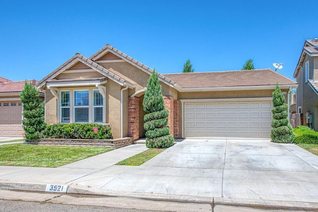 single story home with driveway, a garage, stucco siding, and a tile roof